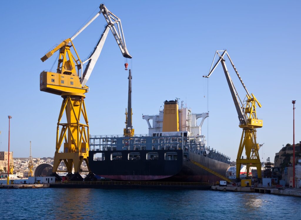 Ship in dry dock with harbour cranes