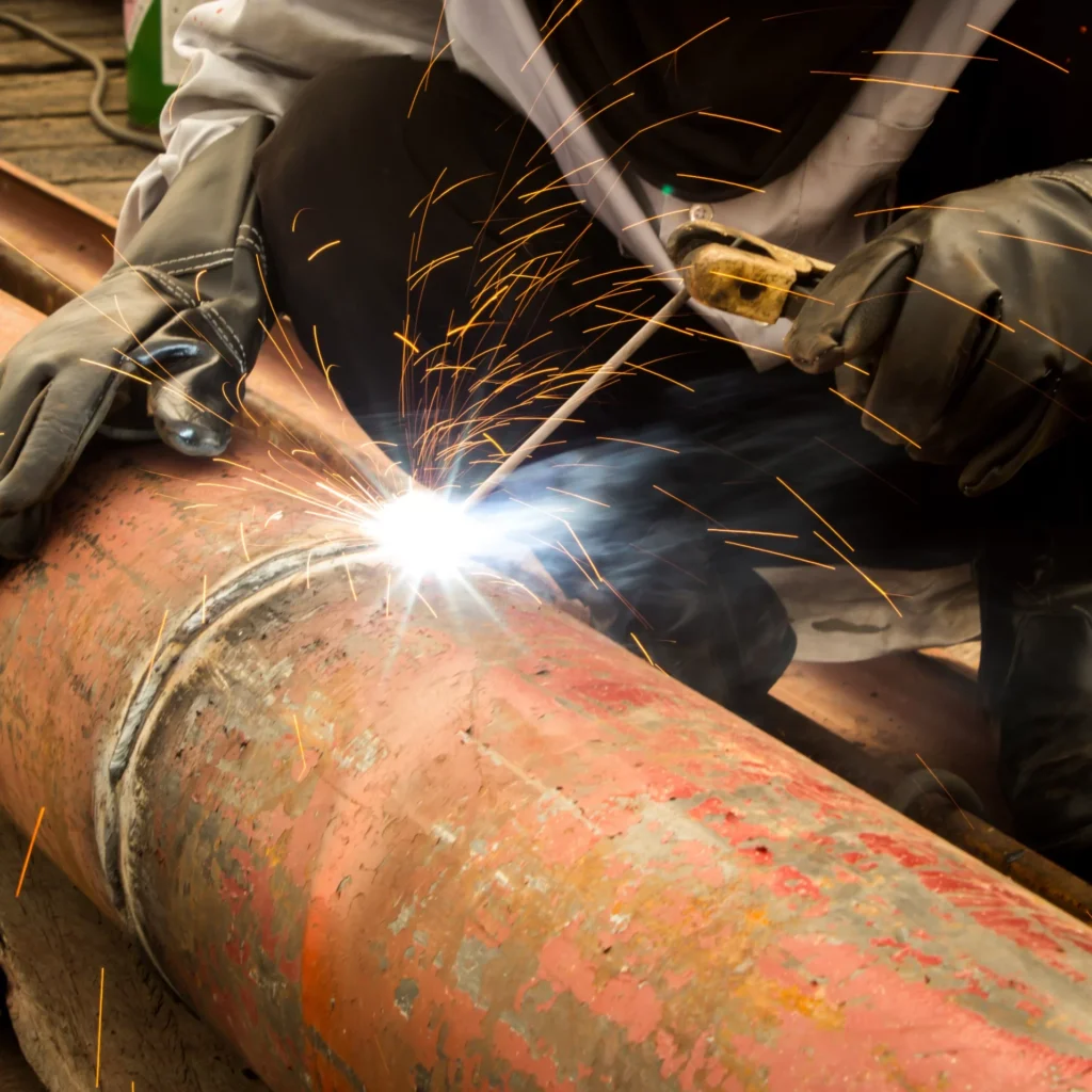 Welding an orange steel pipe