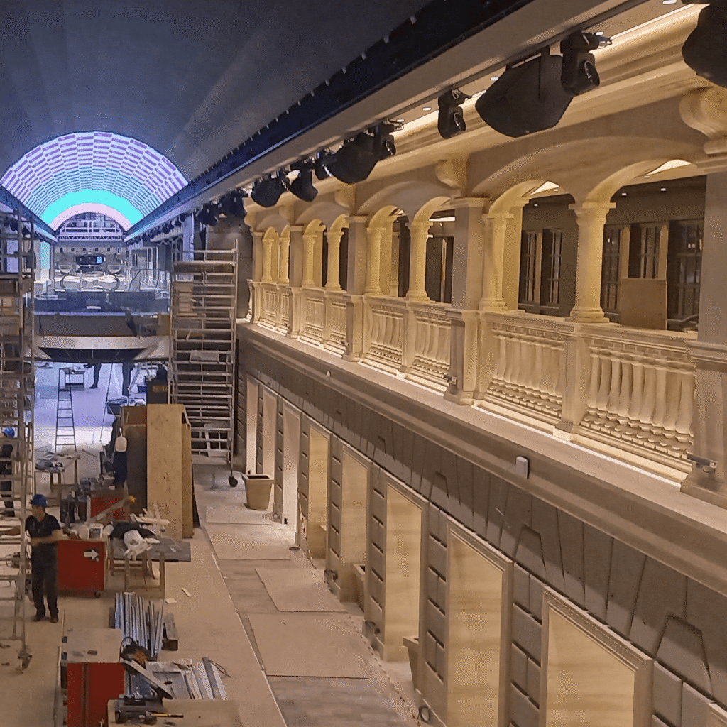 Cruise ship interior during outfitting, with arched ceiling and columns