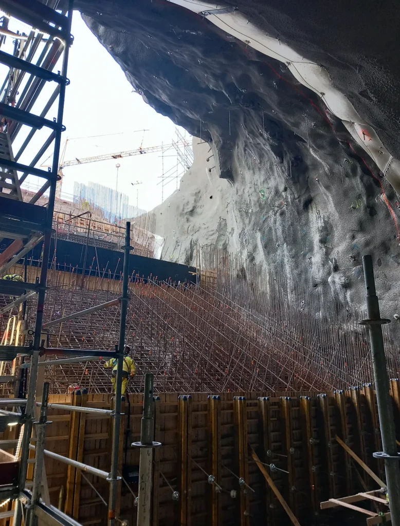 Concrete and rebar works against a rock wall
