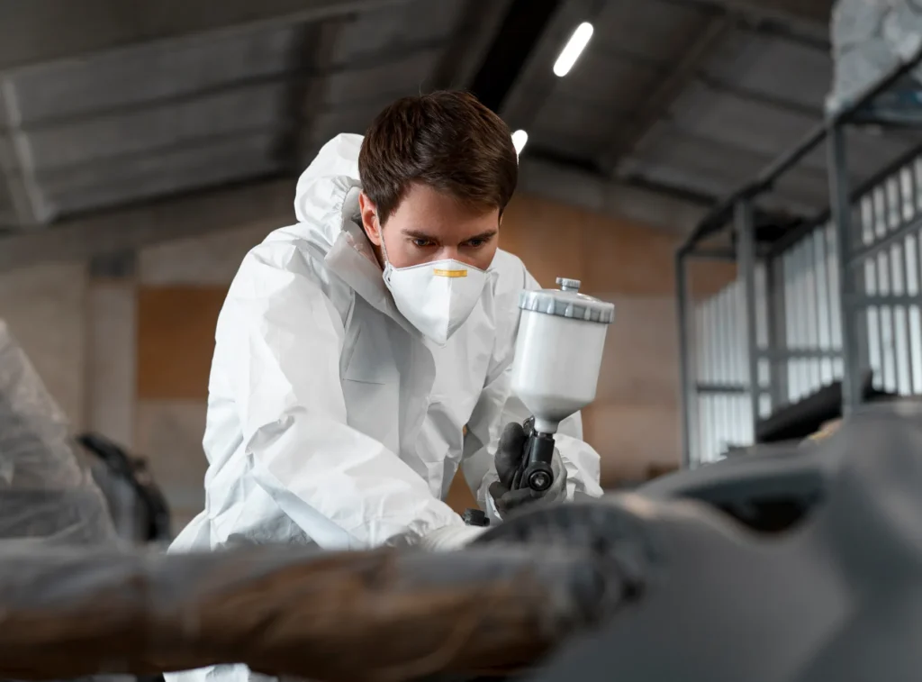 Specialist spray painting in a protective suit