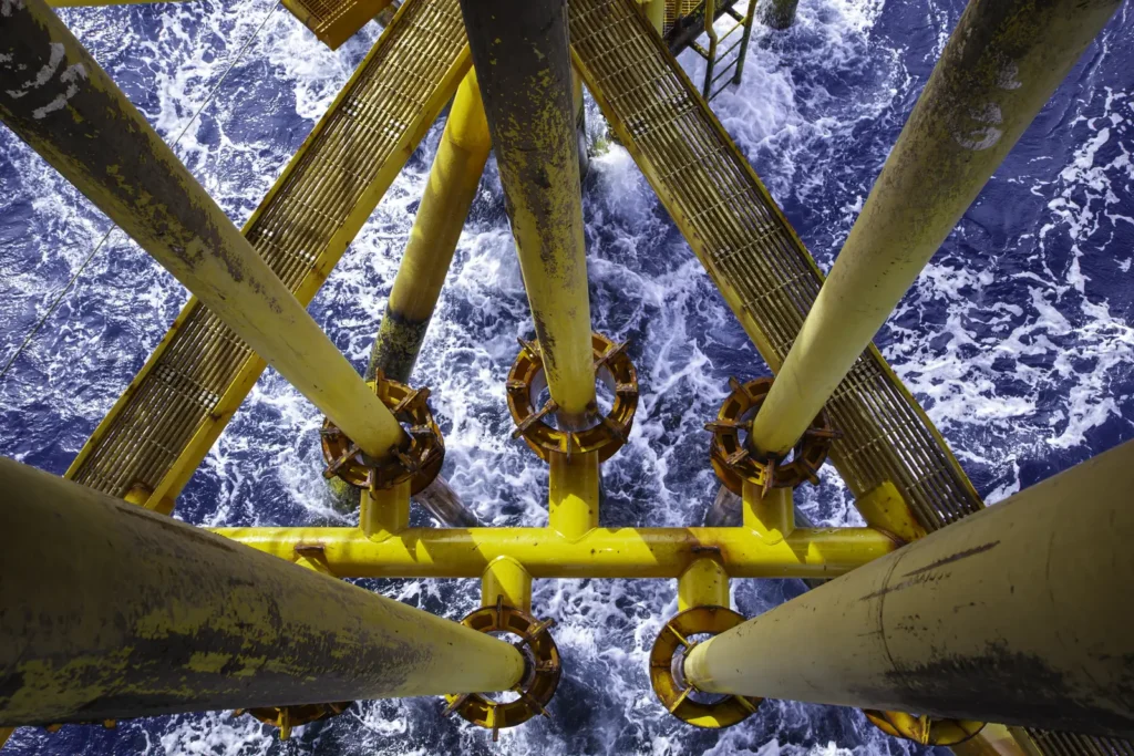 Yellow offshore platform legs above the sea