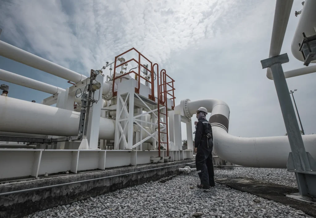 Specialist inspecting industrial piping at a plant