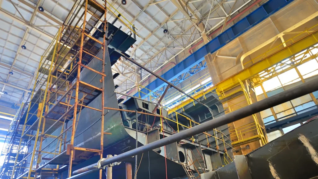Ship hull section under construction in a shipyard hall